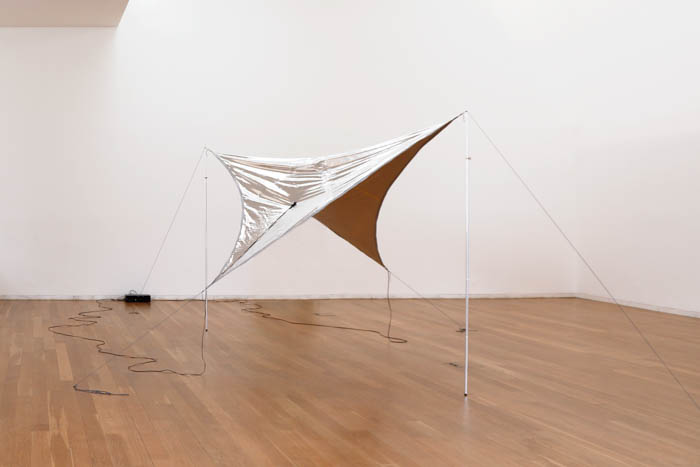 Cobertor de sobrevivência, postes de aço, cordas de poliamida,
altifalantes de contacto, cabos, amplificador, mediaplayer, stereo,
10’00’’ (loop)
dimensões: 10 × 7 × 2,5m